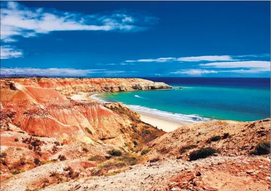  ?? Getty Images ?? THE CLIFFS and bay of Maslin, which is South Australia’s oldest “unclad” beach. Find a quiet stretch of sand to indulge in a gourmet picnic; clothing is optional.