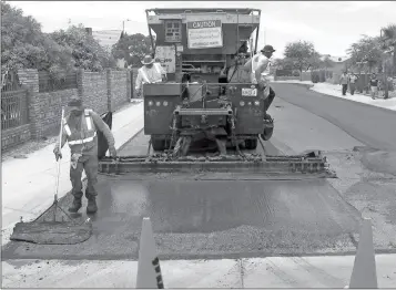  ?? FILE PHOTO ?? WORKERS APPLY NEW asphalt to a street in San Luis, Ariz. City officials have identified road maintenanc­e as a priority in the new fiscal year that began this month.