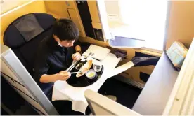  ??  ?? A diner tucks into his £391 onboard meal. Views of the tarmac come gratis. Photograph: All Nippon Airways/AFP/Getty Images