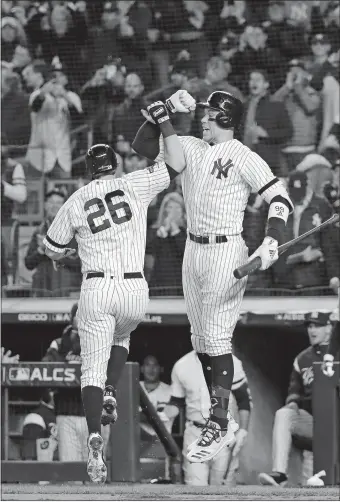  ?? FRANK FRANKLIN II/AP PHOTO ?? The Yankees’ DJ LeMahieu, left, celebrates with Aaron Judge after hitting a leadoff home run against the Astros during the first inning of Game 5 of the American League Championsh­ip Series at Yankee Stadium in New York. Go to theday.com for a recap of this game, which ended too late for this edition.