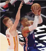  ?? BEN MARGOT/ASSOCIATED PRESS ?? Washington Wizards’ Russell Westbrook shoots past Atlanta Hawks’ Kevin Huerter (3). Westbrook had 28 points, 13 rebounds and 21 assists for his 182nd triple-double that broke the NBA record.