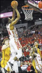  ?? Chase Stevens Las Vegas Review-Journal ?? UNLV forward Joel Ntambwe goes to the basket on an alley-oop pass from Rebels guard Amauri Hardy, bottom right, against Wyoming on Saturday.