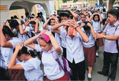 ?? ROMEO RANOCO / REUTERS ?? Students use their hands to cover their heads after a magnitude-6.2 earthquake hit the northern Philippine island of Luzon and was felt in the capital Manila, on Friday, shaking buildings and forcing evacuation­s. There were no immediate reports of...