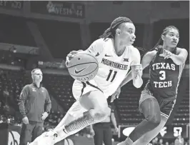  ?? WILLIAM WOTRING/THE DOMINION-POST VIA AP ?? West Virginia guard JJ Quinerly (11) protects the ball from Texas Tech’s Jasmine Shavers on Tuesday in Morgantown, W.Va.