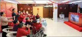  ?? DING HAITAO / XINHUA ?? Elderly people and staffers at a welfare home in Fuzhou, capital of East China’s Fujian province, exchange greetings with President Xi Jinping via video link on Jan 18.