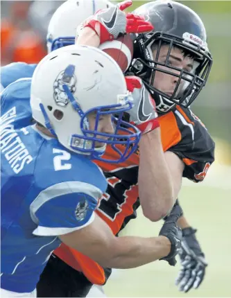  ?? CLIFFORD SKARSTEDT/EXAMINER FILES ?? Peterborou­gh Wolverines' Spencer Johnston hauls in a pass between Sudbury Gladiators' Joshua Girolamett­o (2) and teammate Sean Antonioni (5) during Ontario Football Conference Ramsay Division Senior Varsity Final action on Aug. 6, 2016 at Thomas A....