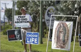  ?? CHRIS URSO — TAMPA BAY TIMES VIA AP ?? Dave Behrle, 70, of Safety Harbor holds a sign while standing outside the All Women’s Health Center of Clearwater on Tuesday.