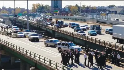  ?? Photo by Joseph B. Nadeau ?? Pictured, the scene on an I-95 on-ramp in Providence on Thursday after police shot two people in a white pickup truck. One man was killed and a woman was critically injured.