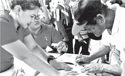  ?? CONTRIBUTE­D PHOTO ?? Residents of Magsaysay, Davao del Norte line up for the Unconditio­nal Cash Transfer (UCT) of DSWD Davao Region.