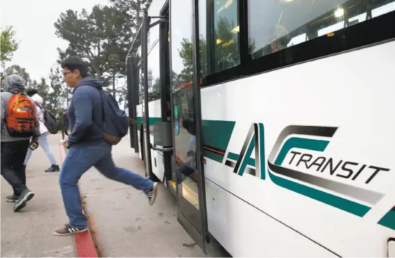  ?? Paul Chinn / The Chronicle ?? Students hop off an AC Transit bus at Skyline High School. The school district and the transit agency are trying to come up with a way to keep the buses rolling.