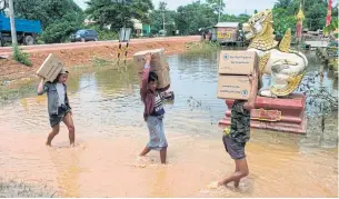  ??  ?? LEFT Volunteers carry relief goods to residents displaced from floods sheltering in a monastery compound in Bago region.