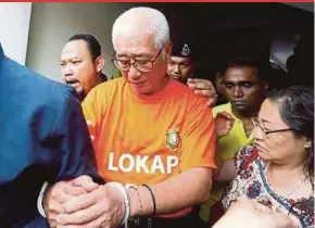  ?? PIC BY RAMDZAN MASIAM ?? Phee Boon Poh (centre) being led to the magistrate’s court in George Town yesterday.