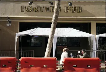  ?? RICH PEDRONCELL­I - THE ASSOCIATED PRESS ?? Diners eat at an outdoor dining area outside of Porter’s Pub on School Street in Lodi, Calif., on Wednesday, Dec. 9.