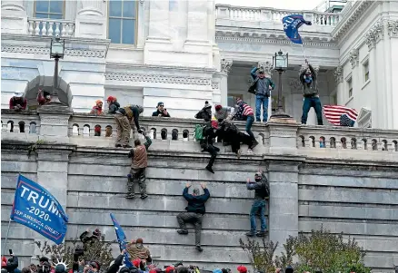  ?? AP ?? Supporters of President Donald Trump, pictured left, climb the west wall of the US Capitol building yesterday.
