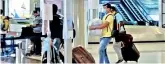  ??  ?? A passenger carries luggage in his hands at airport