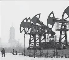  ?? ANDREY RUDAKOV/BLOOMBERG ?? A worker passes a line of oil pumping jacks outside the village of Nikolo-Beryozovka near Neftekamsk, Russia, in 2016.