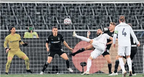  ?? /EFE. ?? Con este complicado remate, a pase de Casemiro, Karim Benzema marcó el primer gol del conjunto español, que cerca estuvo de sucumbir en su visita a Alemania.