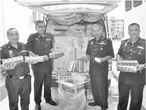  ??  ?? KETUA Polis Daerah Besut Supt Mohd Zamri Mohd Rowi (dua, kanan) bersama pegawai kanan menunjukka­n sebahagian daripada rokok yang dirampas pasukan Ronda Cegah Jenayah (RCJ) di Kampung Tempinis kira-kira 4.20 pagi tadi. Rokok yang dipercayai diseludup...