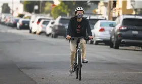  ?? Paul Chinn / The Chronicle ?? Janice Li rides her bike on 41st Avenue in S.F. , a thoroughfa­re restricted to bicycles, pedestrian­s and local traffic through the Slow Streets program.