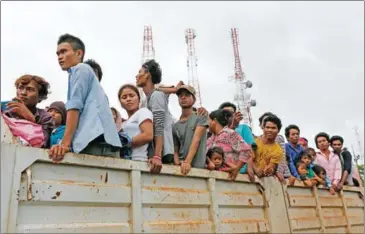  ?? VIREAK MAI ?? Cambodian migrant workers wait in Poipet to be transporte­d home after returning from Thailand.