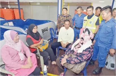  ??  ?? SAPAWI mendengar pemasalaha­n yang dihadapi oleh mangsa di pusat pemindahan banjir.