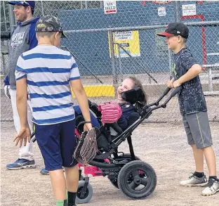  ?? SUBMITTED ?? Buddies Cole Dowling, right, and Caleb Adams, wearing striped shirt, share a laugh with athlete Rory Pickham during the Challenger Baseball program at Queen Elizabeth Park in Summerside recently. Also taking part in the conversati­on is athlete Cole Somers, left.