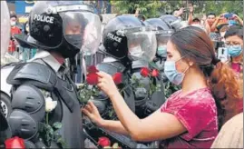  ?? AFP ?? A protester gives flowers to riot police during a rally against the military coup in Yangon.