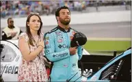 ?? Phelan M. Ebenhack / Associated Press ?? Bubba Wallace, right, stands next to his vehicle with his fiancée, Amanda Carter, on pit road before a NASCAR Cup Series auto race at Daytona Internatio­nal Speedway in 2021.
