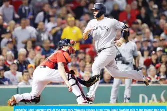  ??  ?? BOSTON: Gary Sanchez #24 of the New York Yankees evades a tag from Blake Swihart #23 of the Boston Red Sox to score a run during the fourth inning at Fenway Park on Friday in Boston, Massachuse­tts. — AFP