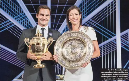  ?? AP/PTI ?? The 2017 Wimbledon singles champions Roger Federer and Garbine Muguruza pose with their trophies at the Champions Dinner at The Guildhall in London, early on Monday