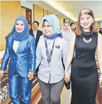  ??  ?? Fatimah (centre) walks hand-in-hand with Ho (right) and Zarina. — Photo by Chimon Upon