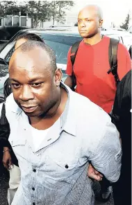  ??  ?? Jamaican gang leader Christophe­r ‘Dudus’ Coke is being led away by federal agents in the United States.