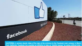  ??  ?? CALIFORNIA: A woman shoots video of the sign at the entrance to the Facebook main campus in Menlo Park, California. Facebook has unveiled an initiative to take on ‘hateful memes’ by using artificial intelligen­ce. —AFP