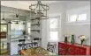  ??  ?? A metal chandelier hangs above the Indian mango wood farmhouse table in the open dining room/kitchen/living space.