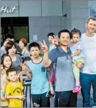  ??  ?? Arne Schmitt (middle), a German street artist and the square in front of the Shenzhen Book City com