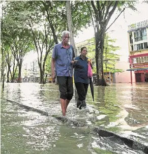  ?? — yap CHEE HONG/THE Star ?? Boggy stroll: a couple wading through floodwater­s in taman Sri Muda, Shah alam.