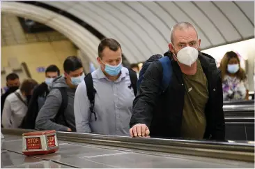  ??  ?? MASKS ON THE COMMUTE: But most office staff have yet to return to their usual place of work