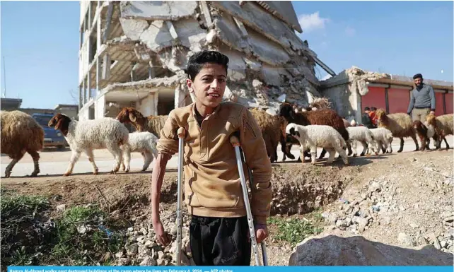  ?? ?? Hamza Al-Ahmed walks past destroyed buildings at the camp where he lives on February 4, 2024. — AFP photos