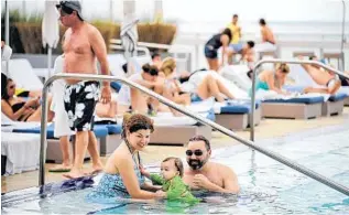  ?? SUSAN STOCKER/STAFF PHOTOGRAPH­ER ?? New York tourists Denise and Stan Dlugozima and their daughter, Emma, 1, enjoy the pool at the W Hotel on Fort Lauderdale beach. Tourism improved in 2012, with 12 million visitors coming to Broward County.