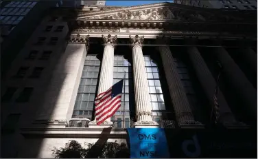  ??  ?? An American flag flies Thursday at the New York Stock Exchange, where stocks fell after a report of continued layoffs in the U.S. (AP/Mark Lennihan)