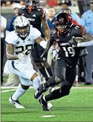  ?? AP-Timothy D. Easley / ?? Louisville running back Hassan Hall runs from the pursuit of Georgia Tech defensive back Juanyeh Thomas.