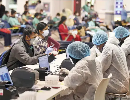  ?? AFP ?? Members of an Indian medical team register for testing upon their arrival at Dubai Internatio­nal Airport to help with containing the coronaviru­s pandemic.