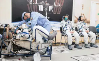  ?? | Reuters | Roscosmos ?? INTERNATIO­NAL Space Station crew members Kathleen Rubins of Nasa, Sergey Ryzhikov and Sergey Kud- Sverchkov of the Russian space agency Roscosmos during a space suit check at the Baikonur Cosmodrome, Kazakhstan, before take- off yesterday.