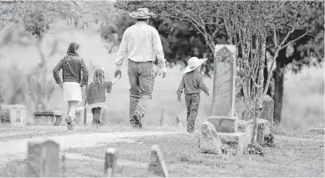  ?? Eric Gay / Associated Press ?? A family arrives for a grave-side service for Richard and Therese Rodriguez on Saturday at the Sutherland Springs Cemetery.