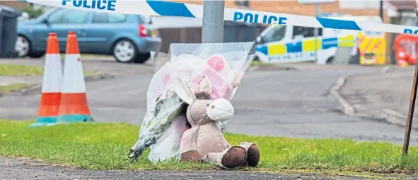  ??  ?? A soft toy and floral tributes placed at the entrance to Troon Avenue, Dundee following the death of Bennylyn Burke and her daughter Jellica.