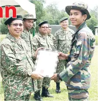 ??  ?? JOHAN pertanding­an menembak M16 PKBM Darat, Muhammad Raihan Badul menerima sijil daripada Raisin.