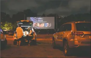  ?? The Associated Press ?? DRIVE-IN: Filmgoers attend the “Nomadland” screening at the Queens Drive-In at the New York Hall of Science during the 58th New York Film Festival in New York on Sept. 26. After a historic season, winter is coming at the drive-in. Summer and early fall have seen the old drive-in transforme­d into a surprising­ly elastic omnibus of pandemic-era gathering. Red-carpet premieres that would normally consume Lincoln Center uprooted to drive-ins.