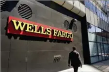  ?? BEN MARGOT — THE ASSOCIATED PRESS FILE ?? In this file photo, a man passes by a Wells Fargo bank in Oakland. On Tuesday Wells Fargo’s top management and board of directors faced irritated investors for the bank’s first big shareholde­r meeting since the scandal over its sales practices led to...