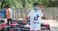  ?? SAJJAD HUSSAIN / AFP ?? A vendor poses in front of his stall with a T-shirt bearing the logo of the video-sharing applicatio­n TikTok in New Delhi on Tuesday. The Indian government announced a decision on Monday to block 59 Chinese apps citing “sovereignt­y and integrity” concerns.