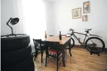  ??  ?? In the spare bedroom/dining room, a tower of tires is being pressed into service as a side table alongside a dining table.